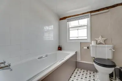 a bathroom with a tub and a toilet and a window at Winter Cottage, Clare in Clare