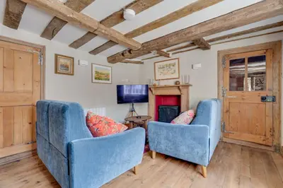 a living room with two blue chairs and a tv at Winter Cottage, Clare in Clare