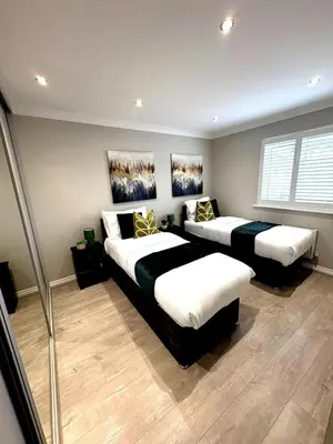 a bedroom with two beds and a window at Luxury home Cheshunt in Wormley