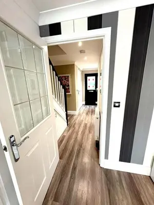a hallway with a white door and wooden floors at Luxury home Cheshunt in Wormley