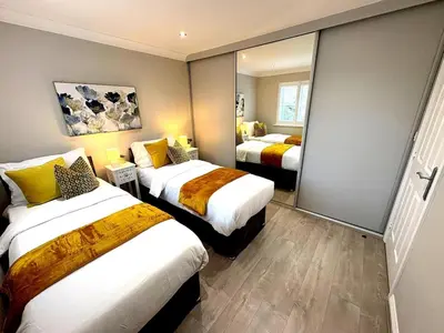 a hotel room with two beds and a mirror at Luxury home Cheshunt in Wormley