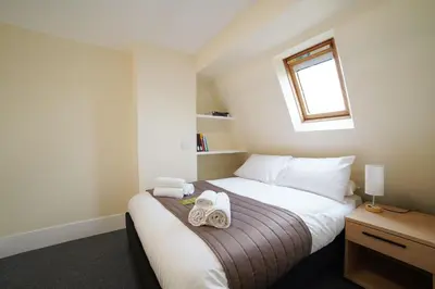 a bedroom with a bed with towels on it at St Catharine's College, Cambridge in Cambridge