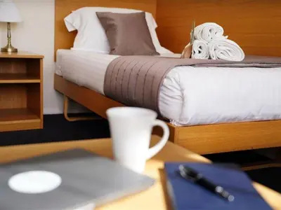a desk with a laptop computer on top of a bed at St Catharine's College, Cambridge in Cambridge
