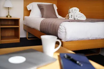 a bedroom with a bed with a laptop on a desk at St Catharine's College, Cambridge in Cambridge