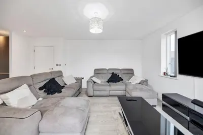 a living room with two couches and a flat screen tv at Lovely 2 Bedroom Apartment in Trumpington