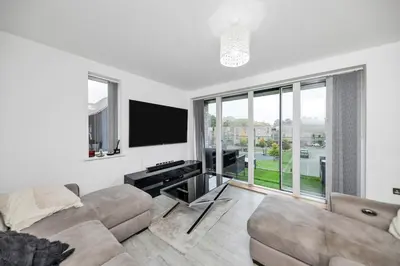 a living room with a couch and a flat screen tv at Lovely 2 Bedroom Apartment in Trumpington