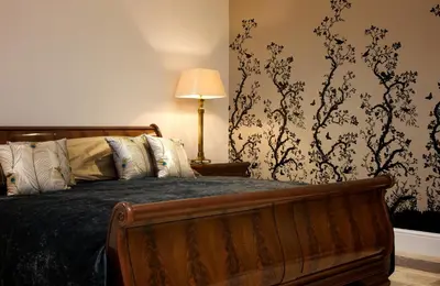 a bedroom with a wooden bed and a lamp at GreyFriars in Colchester