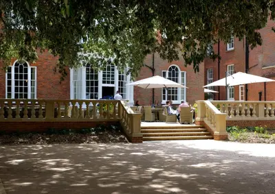 a building with a staircase and tables and umbrellas at GreyFriars in Colchester
