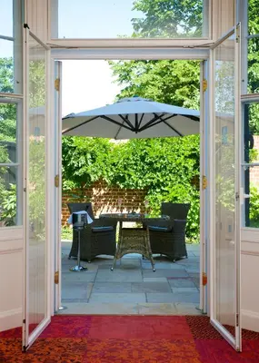an open door to a patio with an umbrella at GreyFriars in Colchester