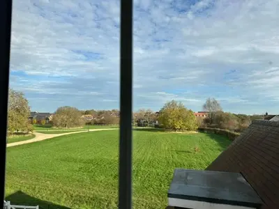 a view of a field of grass from a window at Modern Suite with a Queen Bed, Ensuite & Workspace in Chelmsford