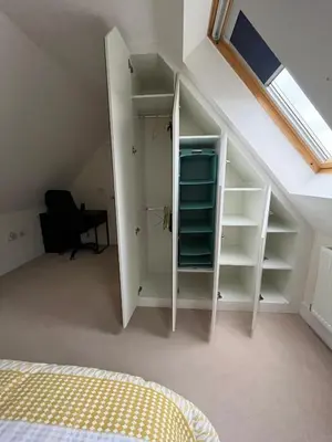 a attic room with a bed and a closet at Modern Suite with a Queen Bed, Ensuite & Workspace in Chelmsford