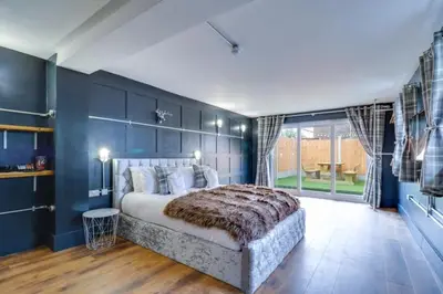 a bedroom with a large bed with blue walls at Studio Apartment with Private Garden in Southend-on-Sea