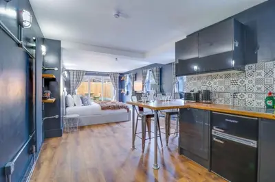 a kitchen with a table and a living room at Studio Apartment with Private Garden in Southend-on-Sea