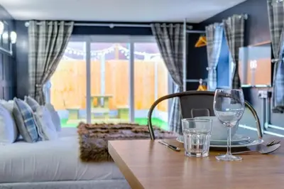 a wooden table with two glasses on top of a table at Studio Apartment with Private Garden in Southend-on-Sea