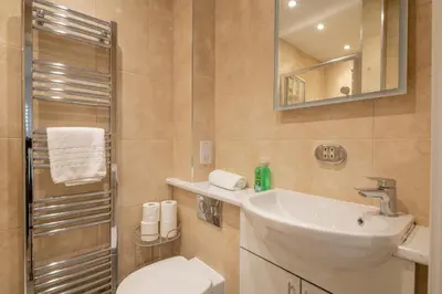 a bathroom with a sink and a toilet and a mirror at Charming Central 1Bed Home in Chesterton