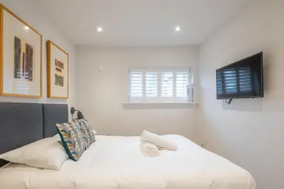 a bedroom with a bed with a television on the wall at Charming Central 1Bed Home in Chesterton
