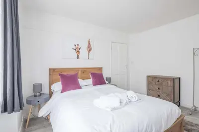 a bedroom with a large white bed with purple pillows at Fabulous 4 Bed Family Home in Cherry Hinton