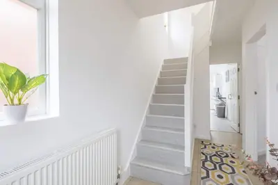 a white staircase in a home with a potted plant at Fabulous 4 Bed Family Home in Cherry Hinton