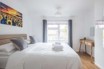 a bedroom with a large white bed with a window at Fabulous 4 Bed Family Home in Cherry Hinton