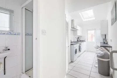 a white bathroom with a sink and a washing machine at Fabulous 4 Bed Family Home in Cherry Hinton