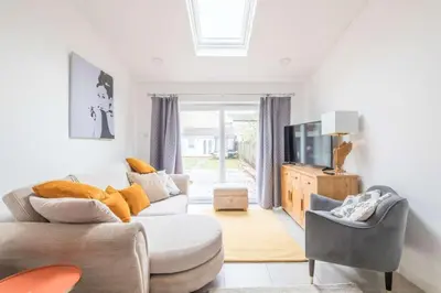 a living room with two couches and a tv at Fabulous 4 Bed Family Home in Cherry Hinton
