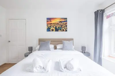a bedroom with a white bed with towels on it at Fabulous 4 Bed Family Home in Cherry Hinton