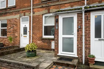 a brick house with white doors and potted plants at 21 Urban Road, sleeps 5 guests, Leiston, near Sizewell, Managed by Aldeburgh Coastal Cottages in Leiston