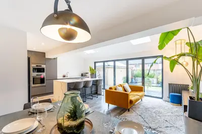 an open kitchen and living room with a table and chairs at Comfortable 3 bedroom Home Chelmsford Sleeps 5 - Pass the Keys in Chelmsford