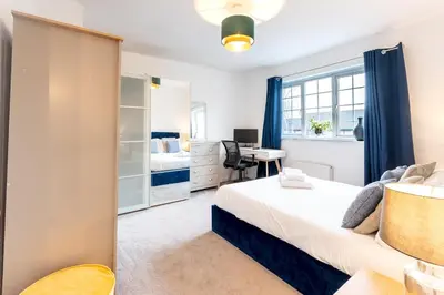 a bedroom with a bed and a desk at Comfortable 3 bedroom Home Chelmsford Sleeps 5 - Pass the Keys in Chelmsford