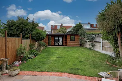 a yard with a fence and a house at Spacious 4-Bedroom Home Near Station Seafront - Pass the Keys in Southend-on-Sea