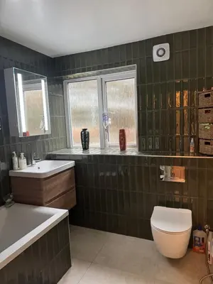 a green tiled bathroom with a toilet and a sink at House in Colchester with parking in Colchester