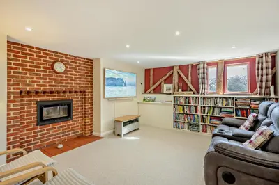 a living room with a couch and a brick fireplace at 6 Bed in Ardleigh oc-b35089 in Ardleigh