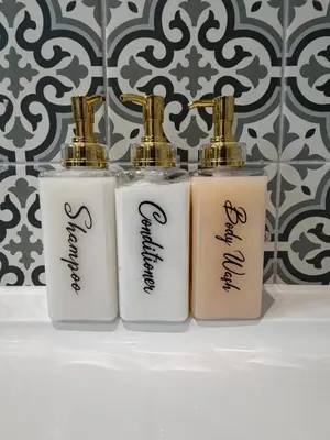 three white and gold bottles on a shelf in a bathroom at NEW Gorgeous Boutique Country Getaway in Tuddenham