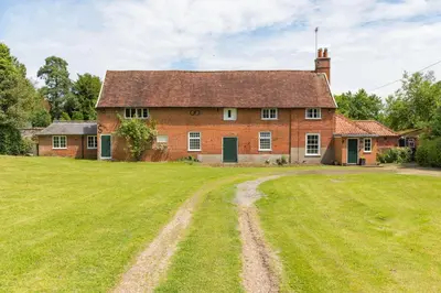 an old brick house with a large grass yard at Gardeners Cottage by Group Retreats in Hadleigh