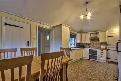 a large kitchen with a table and chairs in it at Gardeners Cottage by Group Retreats in Hadleigh