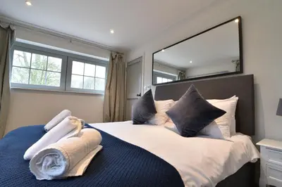 a bedroom with a large mirror above a bed at Charming 6BDR home in the Essex Countryside in Stanford Rivers