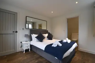 a bedroom with a large bed with towels on it at Charming 6BDR home in the Essex Countryside in Stanford Rivers