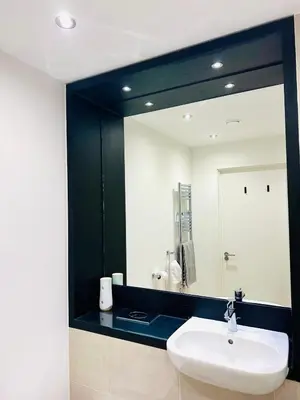 a bathroom with a white sink and a mirror at Bright Corner Apartment by Cambridge Station with Free Allocated Underground Parking & Flexible Beds in Cambridge