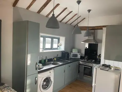 a kitchen with a washing machine and a washer at The Tack Room at Green Farm Lodge in Stowmarket