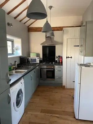 a kitchen with a washing machine and a washer at The Tack Room at Green Farm Lodge in Stowmarket