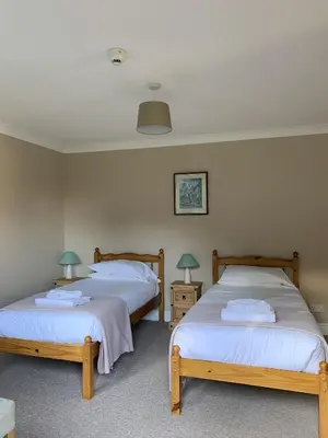 two beds in a room with two tables and two lamps at Lakeside Lodge Golf and Country Club in Huntingdon