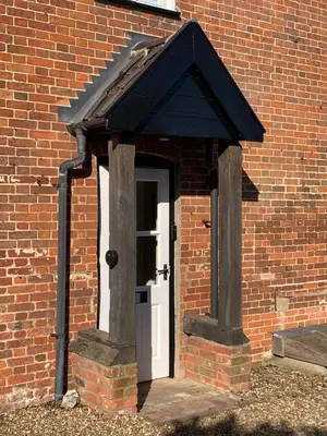 a door in a brick building with a roof at Dog-friendly rural retreat in Bury Saint Edmunds