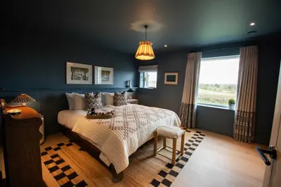 a bedroom with a large bed and a window at The Barn at Manor Farm in Great Glemham