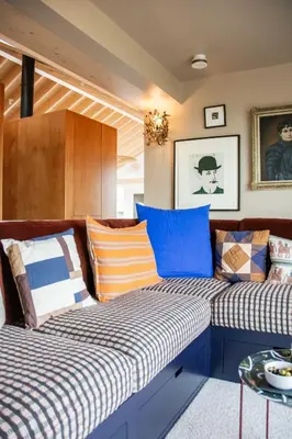 two beds in a room with colorful pillows at The Barn at Manor Farm in Great Glemham