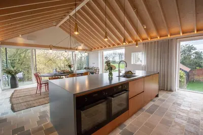 an open kitchen with an island in the middle at The Barn at Manor Farm in Great Glemham