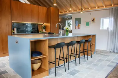 a kitchen with a counter with bar stools at The Barn at Manor Farm in Great Glemham