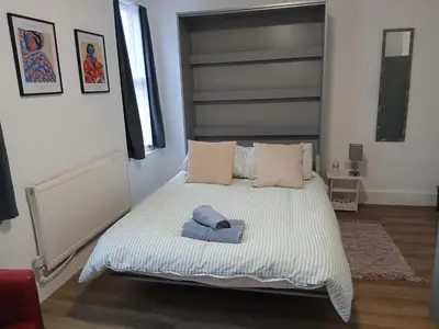 a bedroom with a bed with a blue towel on it at Great En-suite room, room 4 in Ipswich