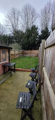 three park benches in a backyard with a table at Great En-suite room, room 4 in Ipswich