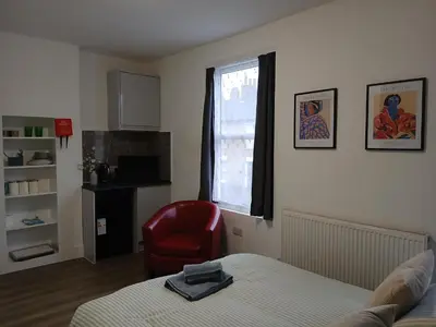 a bedroom with a bed and a chair and a window at Great En-suite room, room 4 in Ipswich
