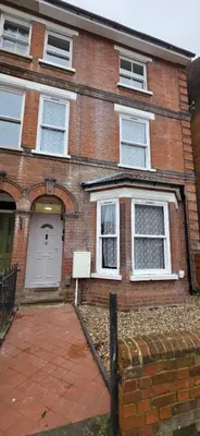 a brick house with a white door and windows at Great En-suite room, room 4 in Ipswich